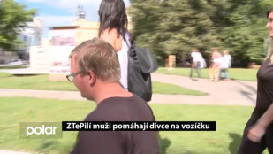 ZTePilí muži pomáhají dívce na vozíčku